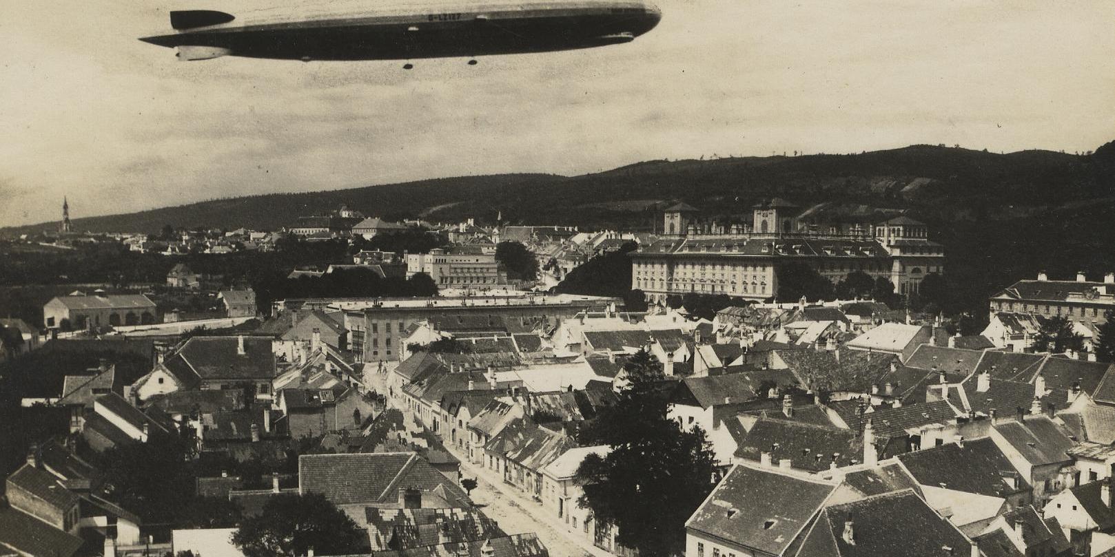 Das Foto vom Eisenstädter Dom aus zeigt das Luftschiff, auf der Straße winken Kinder. 