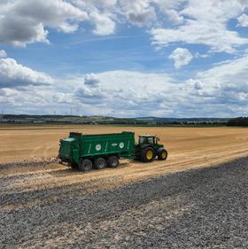 Schlamm wird von Traktor auf dem Feld verteilt 