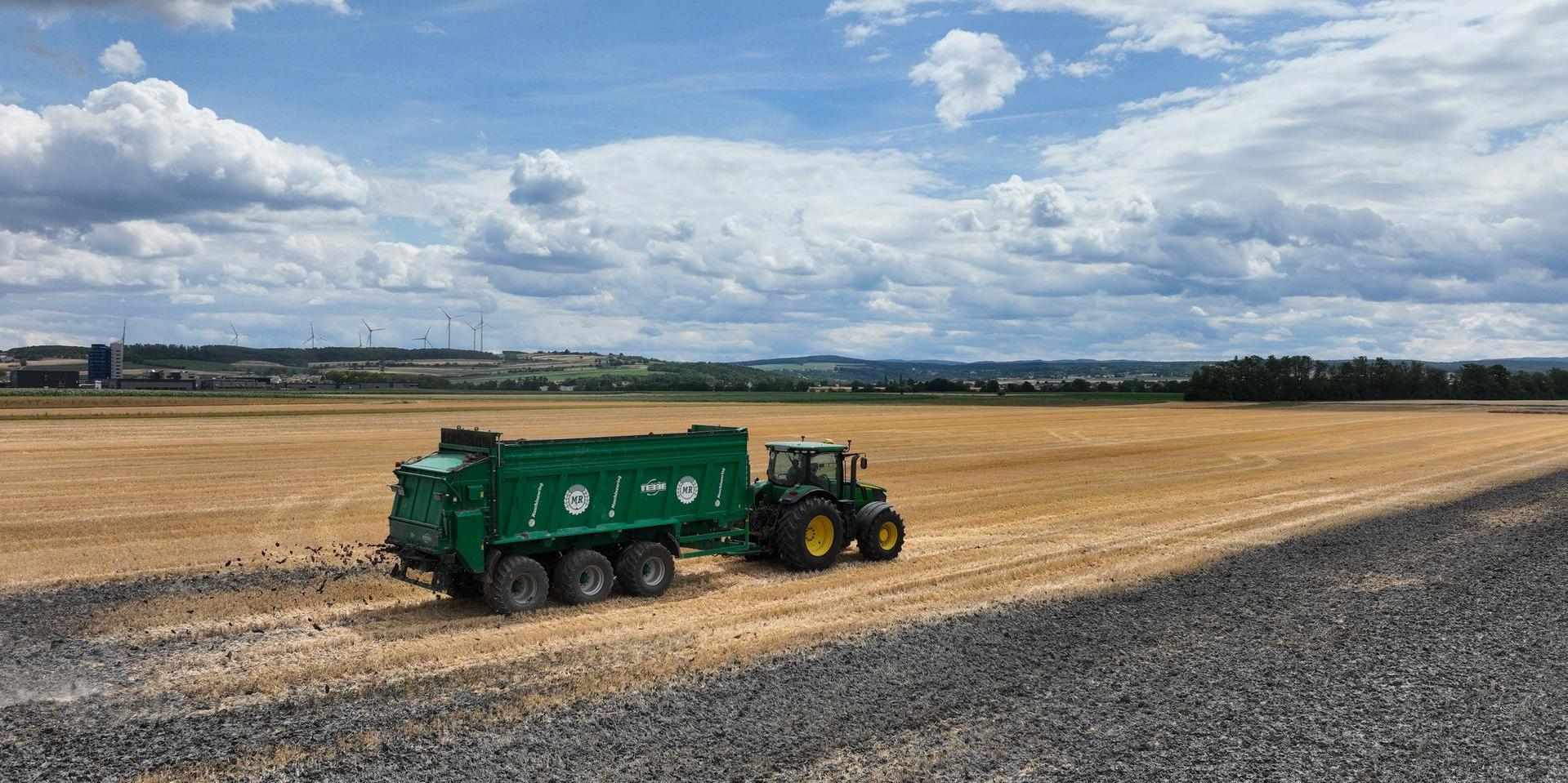 Schlamm wird von Traktor auf dem Feld verteilt 