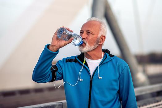 Mann trinkt aus Wasserflasche